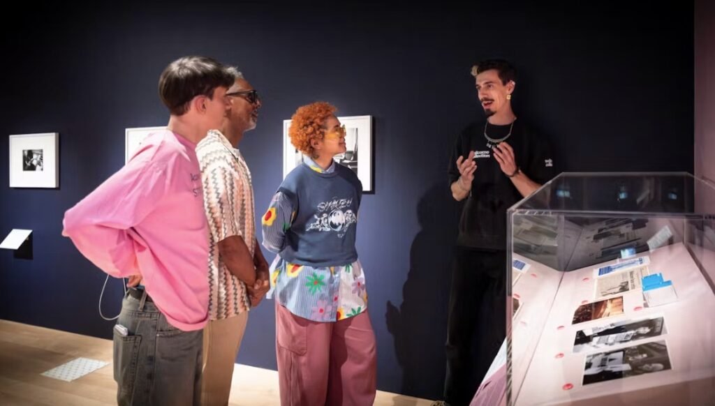 A member of staff takes a group on an tour of an exhibition.