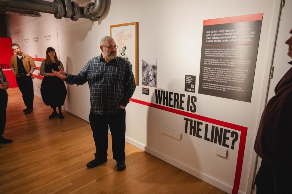 Colour photograph of a person leading a tour in a gallery.