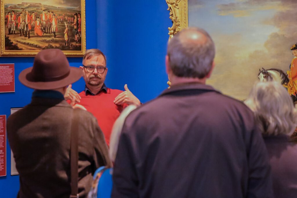 A Deaf guide delivering a tour to a audience
